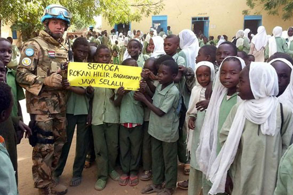 Mayor Inf Freddy Andri R Simanjuntak bersama anak-anak di Sudan, Afrika membentangkan selebaran ucapan selamat HUT Rohil ke 20. (sumber: cakaplah.com)