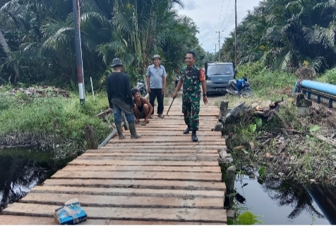 Babinsa Koramil 05/Gas Kopda Umar Nasution Bersama Masyarakat Untuk Memperbaiki Jembatan