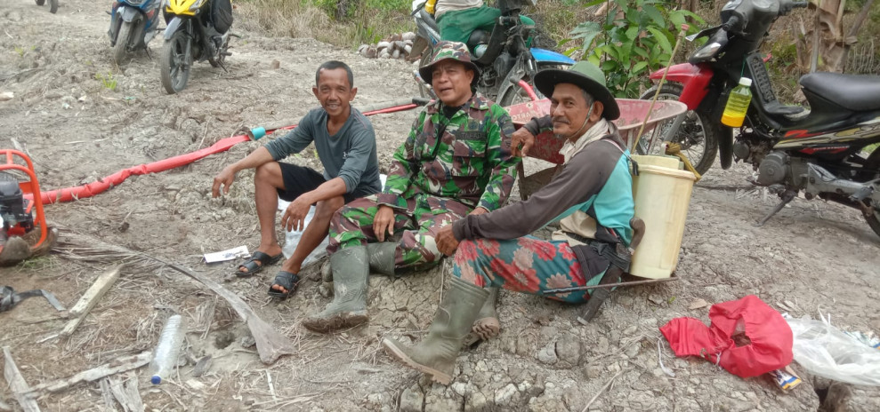 Babinsa Koramil 07/Reteh Bantu Penyiraman Padi di Sungai Batang