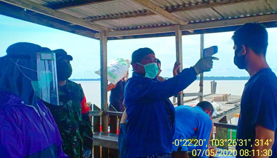 Cegah Covid-19, Babinsa Desa Tanjung Lanjung Lajau Cek Suhu Tubuh Penumpang di Pelabuhan