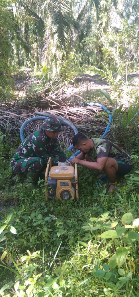 Bersama warga Anggota Satgas TMMD Reguler Ke-110 Kodim 0313 KPR Kuras air yang Banjiri Jalan  Bersama warga Anggota Satgas TMMD Reguler Ke-110 Kodim 0313 KPR Kuras air yang Banjiri Jalan
