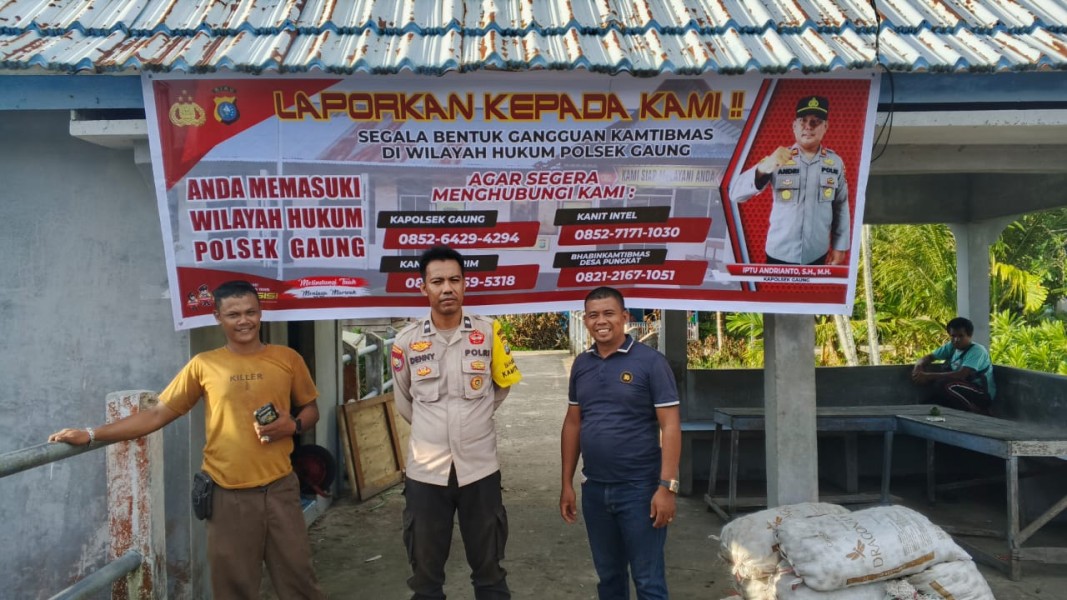 Bhabinkamtibmas Desa Pungkat Pasang Spanduk Harkamtibmas dan Call Center di Binaan