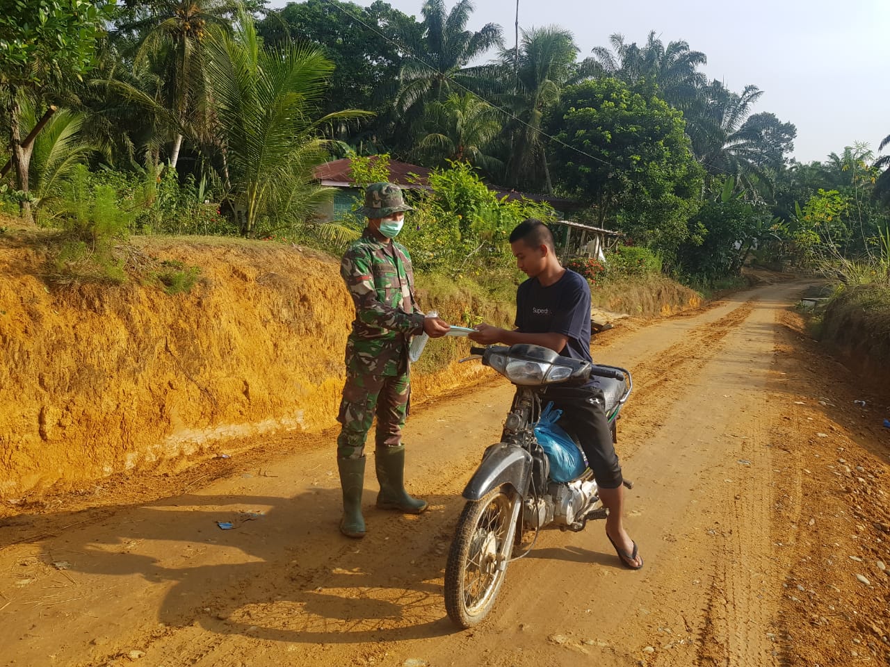 Anggota Satgas TMMD Bagikan Masker pada Warga