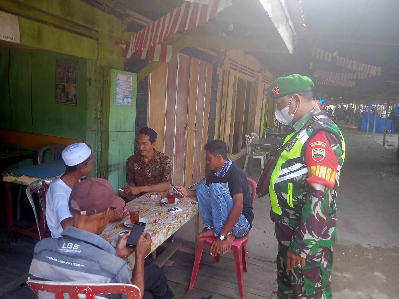 Saat Berbincang Bersama Warga, Anggota Koramil 04/Kuindra Juga Tegakkan Prokes