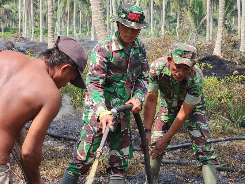 Danramil 10/Plg Bersama Tim Gabungan Lakukan Pendinginan Terhadap Lahan Yang Terbakar