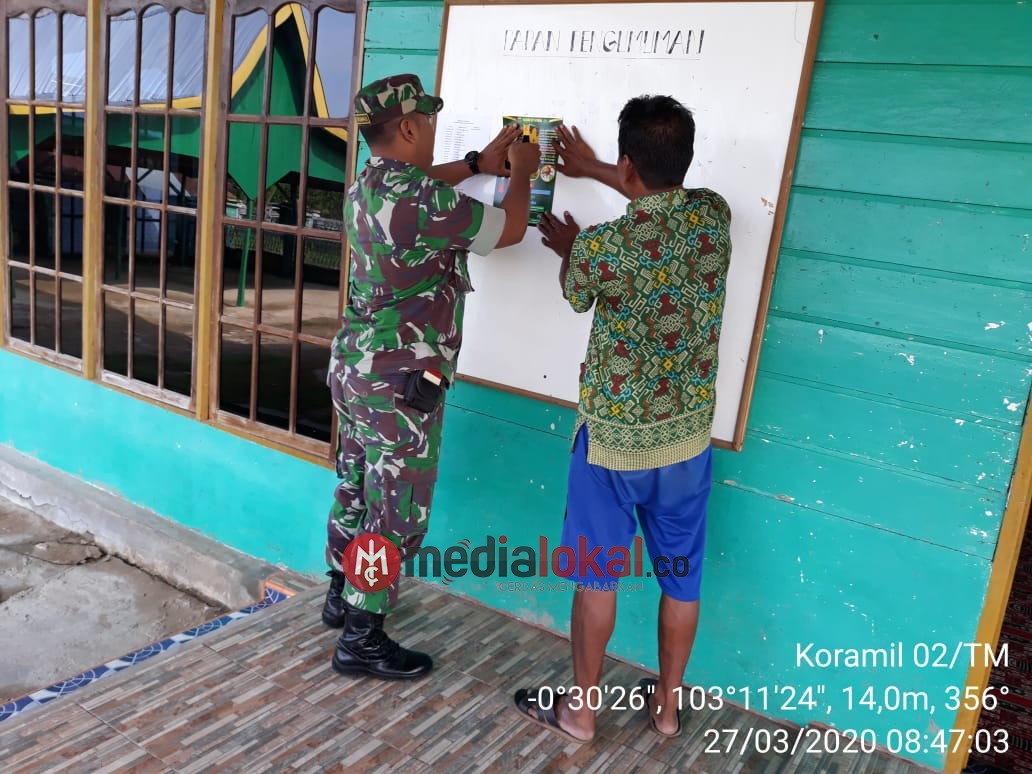 Babinsa Kelurahan Enok Lakukan Pemasangan Brosur Pencegahan Covid-19