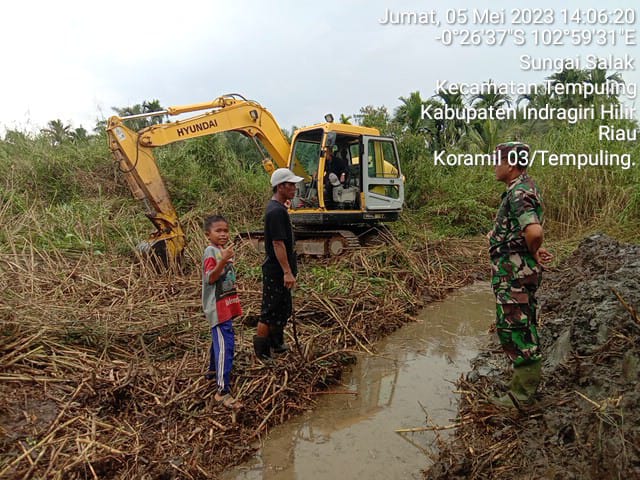 Manfaatkan Waktu Senggang, Babinsa 03/Tpl Pantau Pembuatan Parit Dilapangan Sepak Bola