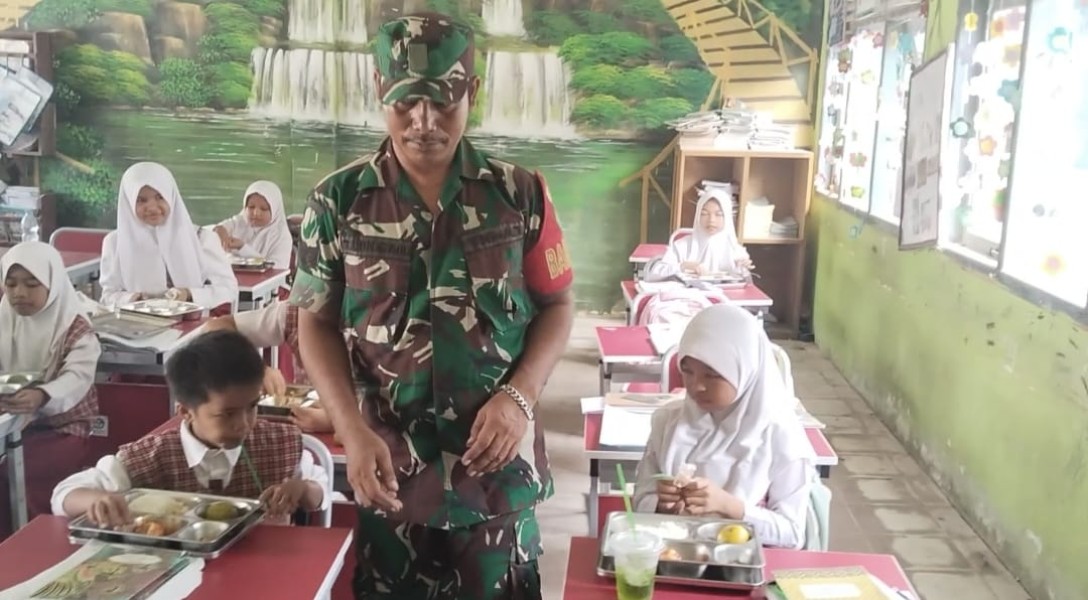 Tingkatkan Gizi Masyarakat, Babinsa Koramil 09/KMG Bagikan MBG di Desa Lintas Utara