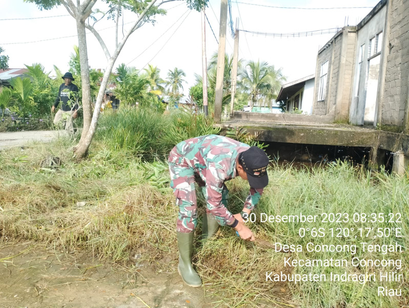 Babinsa Serma Suhaidi Giat Lakukan Pembersihan Sekitaran Parit di Desa Concong Tengah
