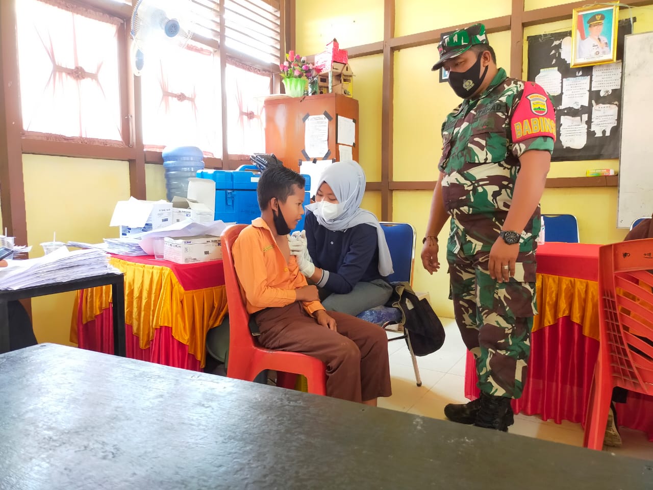 Babinsa Pengalihan Keritang Dampingi Vaksinasi untuk Warga