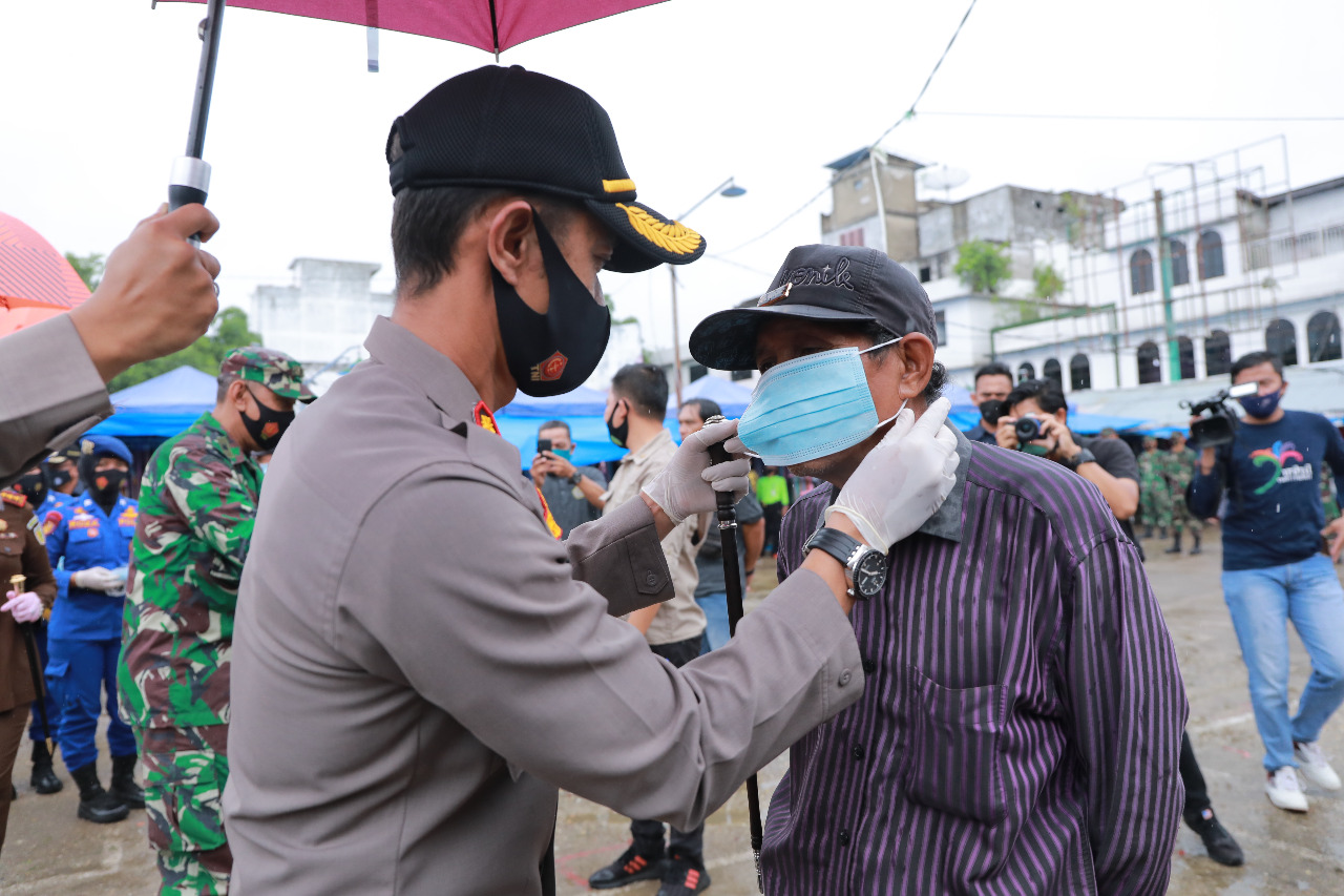Di Tengah Guyuran Hujan, Polres Inhil bersama Forkopimda Bagikan Masker Serentak