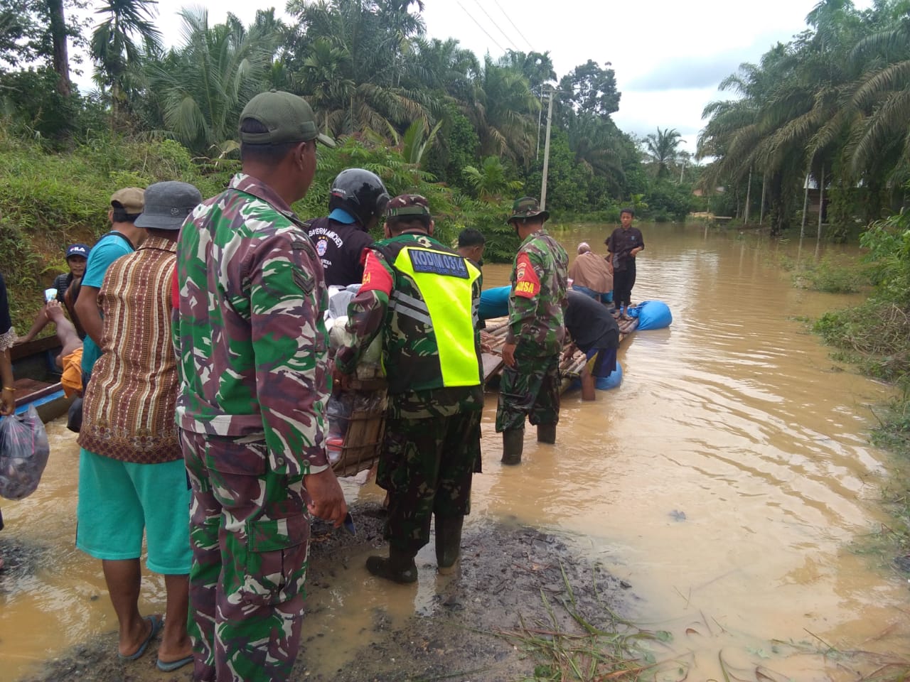 Babinsa Koramil 09/Kemuning Bantu Warga Melalui Jalan yang Putus Akibat Banjir