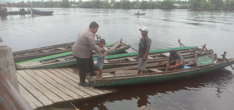 Berikan Rasa Aman, Kanit Samapta Polsek Gaung Bripka Ronal Manulang Bantu Masyarakat Untuk Menyebrang Menggunakan Perahu