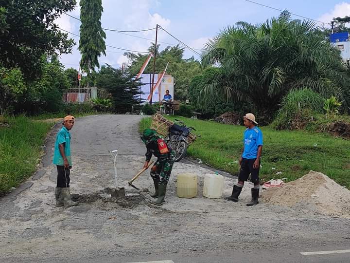 Wujudkan Kebersamaan, Babinsa Koramil 09/Kemuning Perbaiki Jalan yang Rusak Bersama Warga