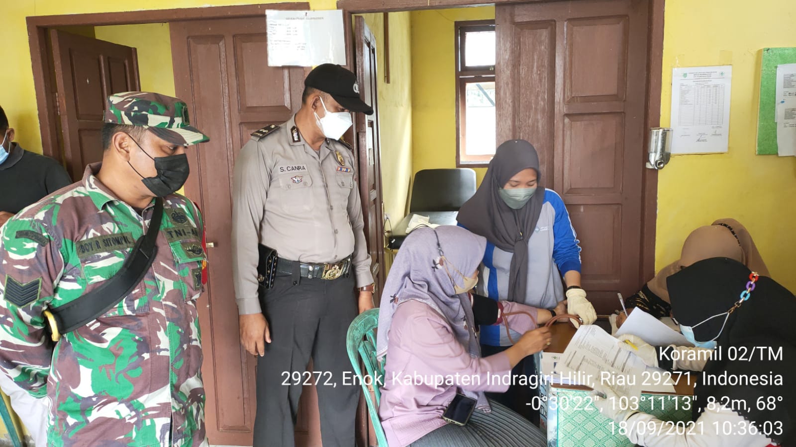 Babinsa Koramil 02/Tanah Merah dan Bhabinkamtibmas Pantau Proses Vaksinasi di Puskesmas Enok