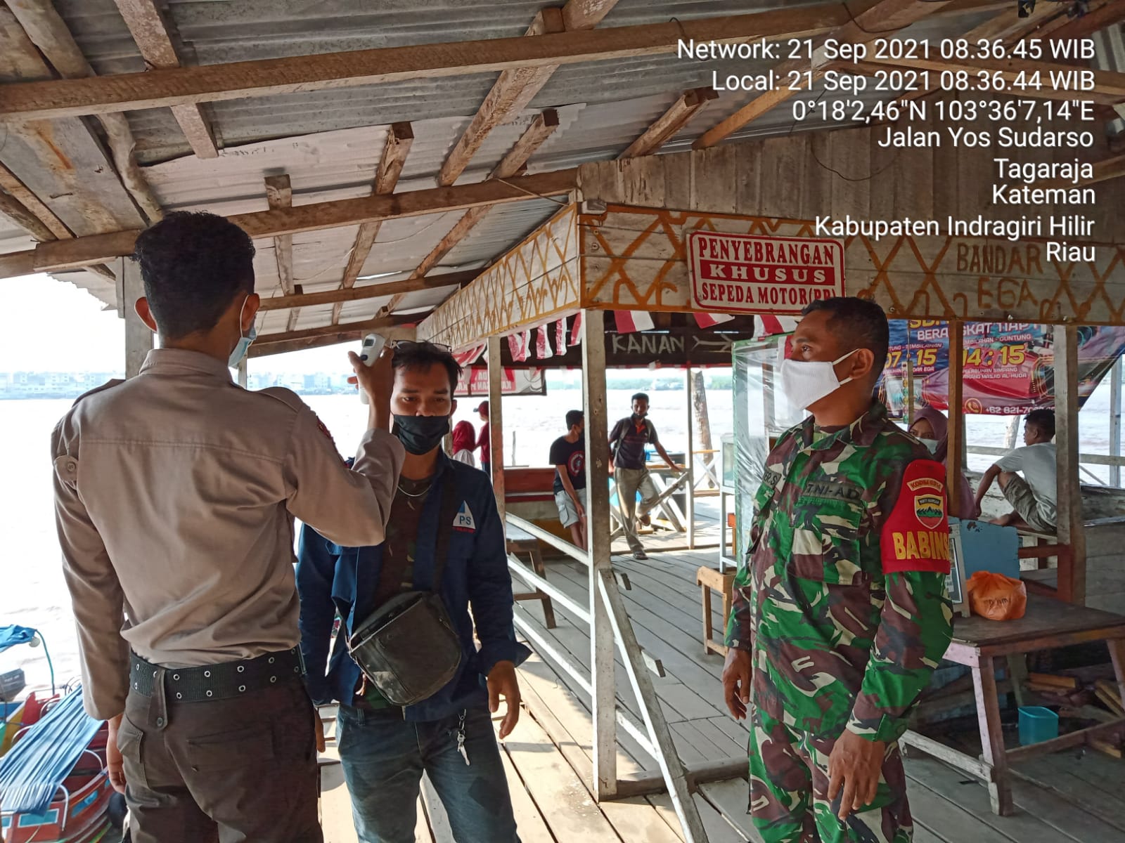 Babinsa Serda Lendi Piter Lakukan Pendampingan Cek Suhu Warga di Desa Air Tawar