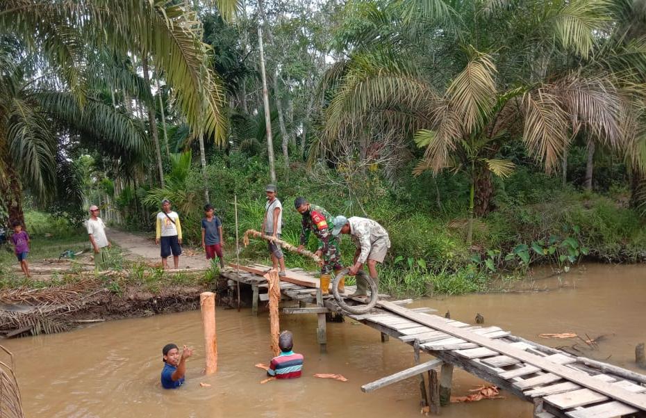 Kompak Bersama Warga, Babinsa Koramil 03/Tempuling Goro Perbaiki Jembatan