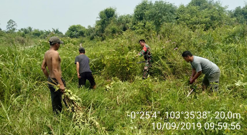 Babinsa Desa Sungai Buluh Goro Bersihkan Semak Belukar di Kiri-Kanan Jalan