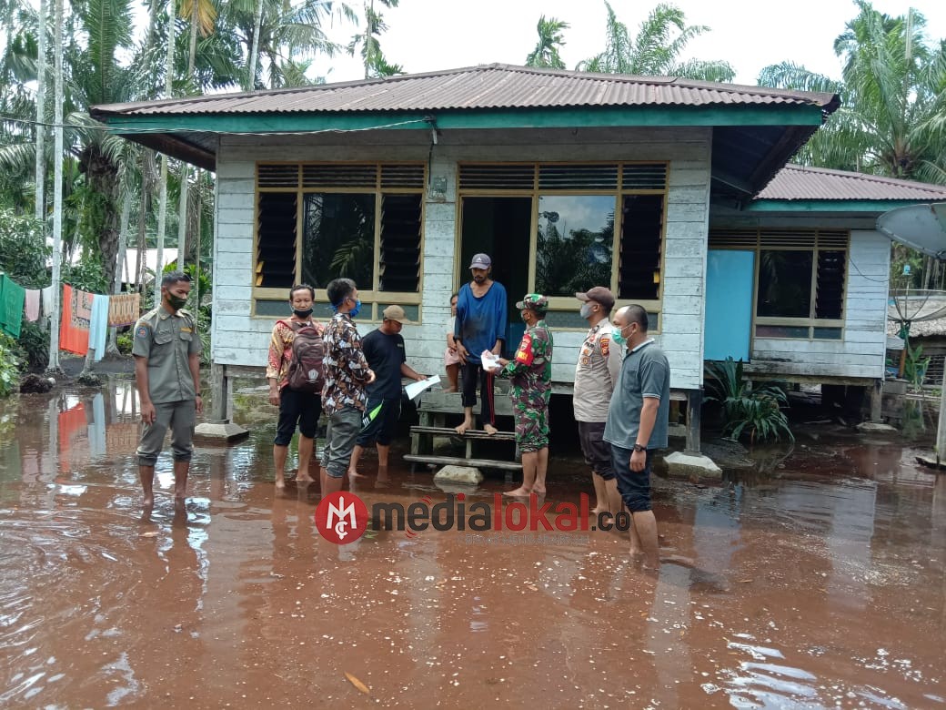 Meskipun Hujan dan Banjir, Babinsa Koramil 03/Tempuling Kawal Pembagian BLT di Desa Binaannya