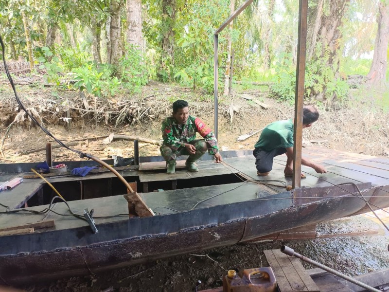 Babinsa Kopka RH Tambunan Peduli dengan Warga, Jalin Komsos saat Warga Perbaiki Perahu Pompong