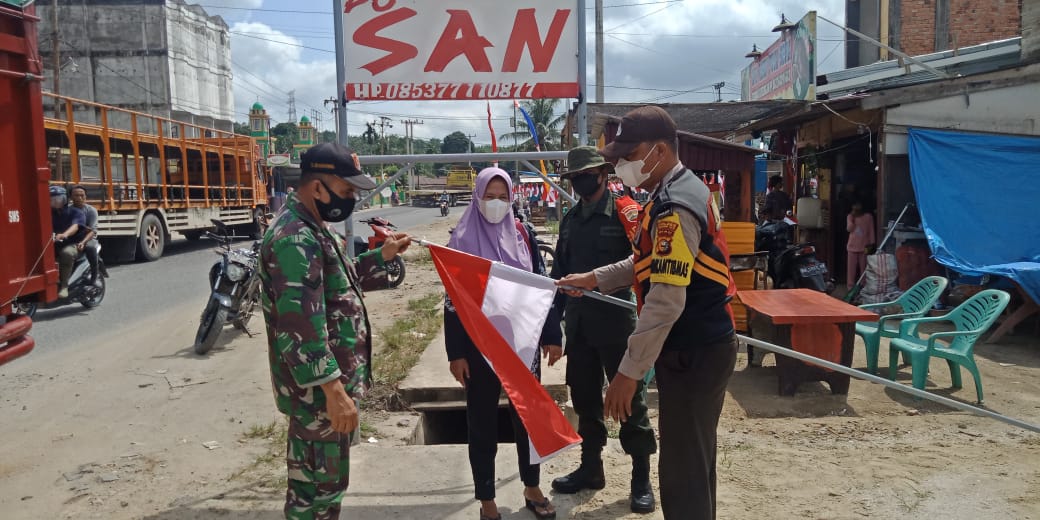 Babinsa Koramil 09/Kemuning Himbau Masyarakat Pasang Umbul-Umbul Sambut Hari Kemerdekaan