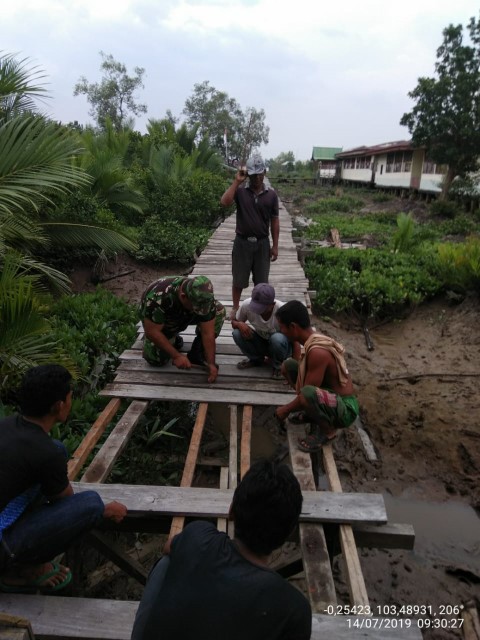 Perbaiki Jalan Jembatan Kayu di Desa Perigi Raja, TNI dan Warga Goro Bersama