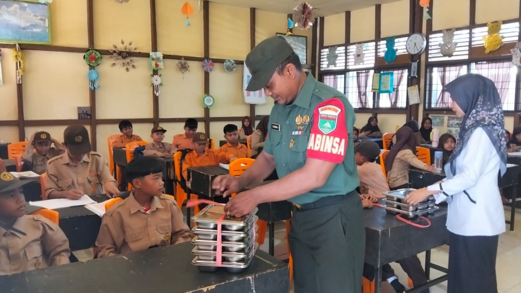Bantu Distribusikan 1.073 Piring MBG di Sencalang dan Pancur, Babinsa Koramil 09/Kemuning Jaga Senyum Anak-anak