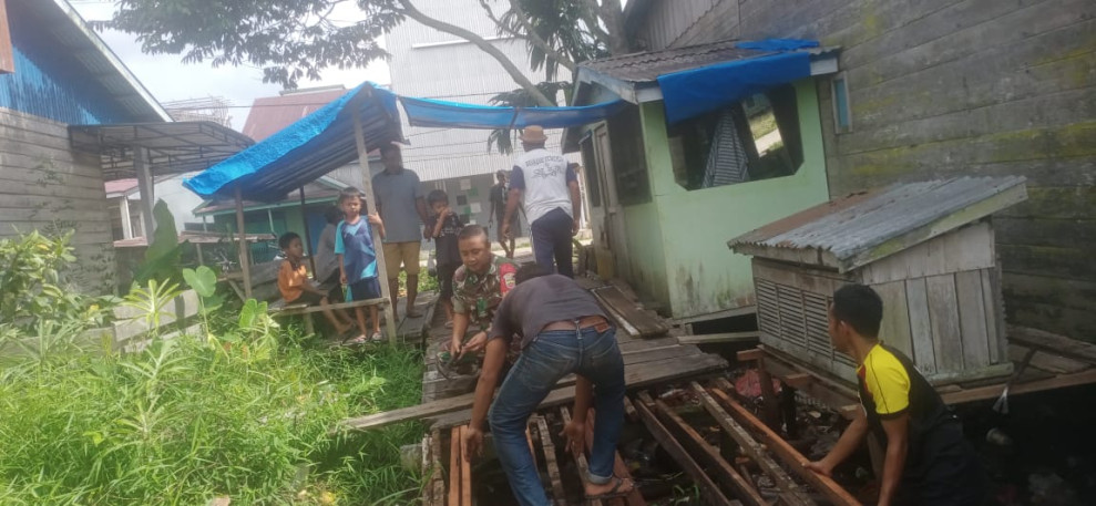 Babinsa Koramil 05/Gas Serda Guntur Goro Bersama Warga Memperbaiki Jembatan