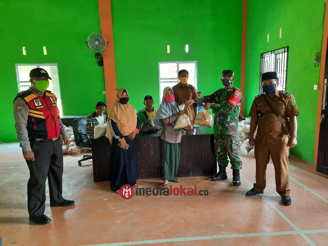 Peduli Covid-19, Babinsa Sungai Rabit Dampingi Aparat Desa Serahkan 150 Paket Sembako Kepada Warga 