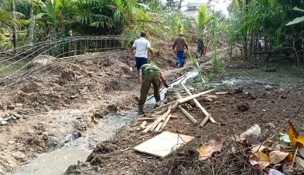 Tim Satgas TMMD Dan Masyarakat Melangsir Material Cor Dengan Gerobak Dorong