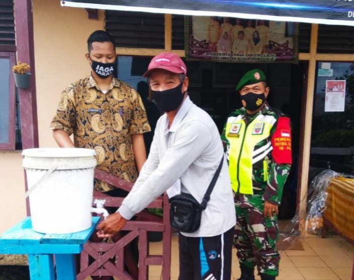 Babinsa Koramil 04/Kuindra Lakukan Penegakan Protkes di Kantor Desa Tanjung Lajau